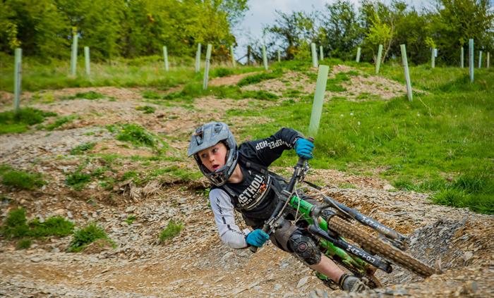 Action shot of a young male rider leant over riding a banked corner